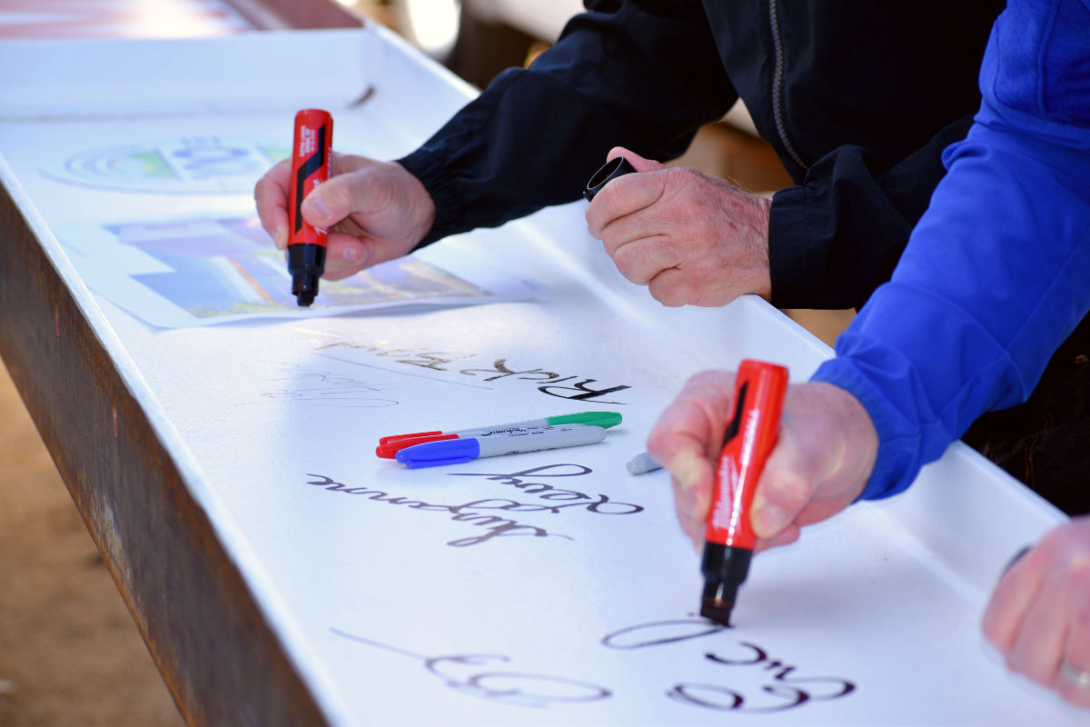 Allan Hancock College faculty signs the last beam at Allan Hancock College for the fine arts building Thursday morning.